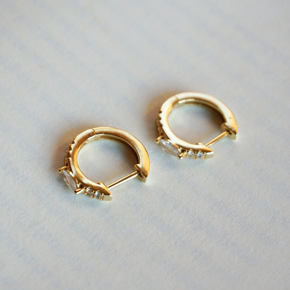 
                  
                    Ellie Gold Huggie Earrings
                  
                